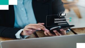 Individual with a laptop and mobile displaying a login screen to cyber security services